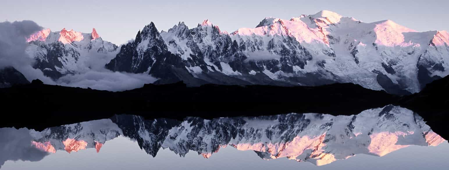 De snedækkede Alper spejler sig i Lac de Chesery, Schweiz