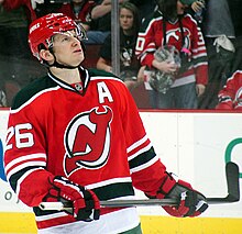 Patrick Elias during an ice hockey game with spectators in the background.