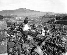 Photographie en noir et blanc d'une large plaine couverte de décombres.