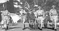 Lt Gen. Arthur Percival, led by a Japanese officer, walks under a flag of truce to negotiate the capitulation of Allied forces in Singapore, on 15 February 1942. All wear standard KD with shorts.