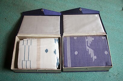 Two muslin sarees packaged in two small cardboard boxes of size approx 8 inches X 6 inches X 2 inches.