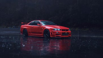 red nissan parked on the road under the rain live wallpaper